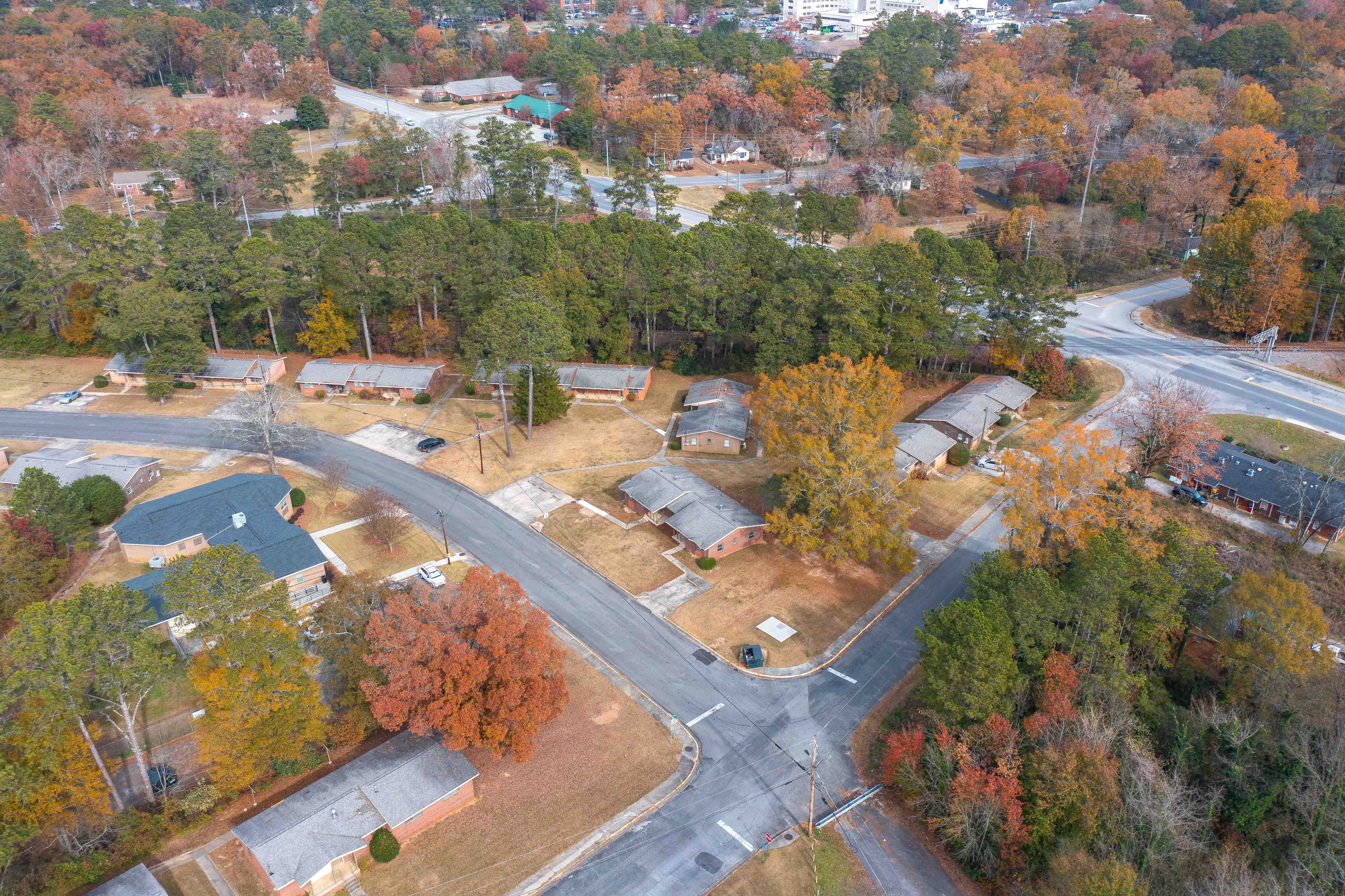 An aerial view of a road network surrounded by trees in autumn.